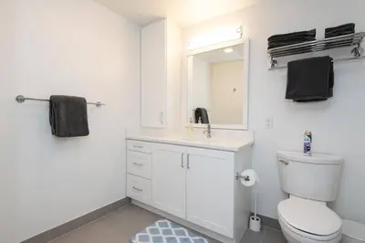 a bathroom with a toilet and a sink and a mirror at Comfy Apt with pool & hot tub in downtown LA' in Los Angeles