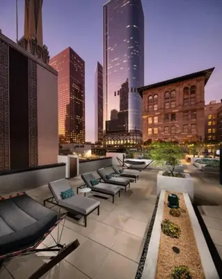a row of chaise lounges on a rooftop in a city at Comfy Apt with pool & hot tub in downtown LA' in Los Angeles