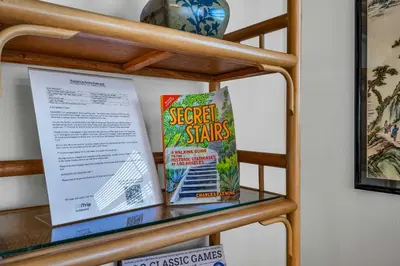 a shelf with two books and a poster on it at Secret Stairs Studio #1 in Los Angeles