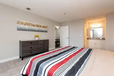 a bedroom with a large bed and a dresser in it at Hollywood 1Bed Apt w Rooftop pool & Panoramic View in Los Angeles