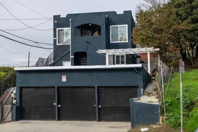 a blue house with two garage doors in front of it at Lovely 3bedroom condo with free parking on premise in Los Angeles