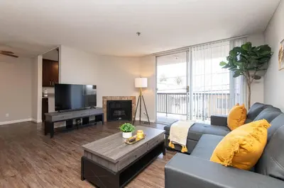 a living room with a blue couch and a tv at Hollywood 2Bed Apt w Rooftop pool & Panoramic View in Los Angeles