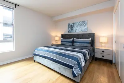 a bedroom with a large bed with blue and white sheets at Comfy Cozy Apt with pool & hot tub in downtown LA' in Los Angeles