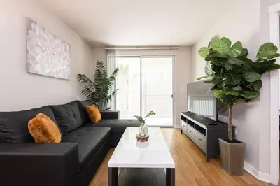 a living room with a black couch and a table at Comfy Cozy Apt with pool & hot tub in downtown LA' in Los Angeles