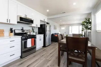 a kitchen with white cabinets and a table and a stove at Lovely 2bedroom condo with free parking on premise in Los Angeles