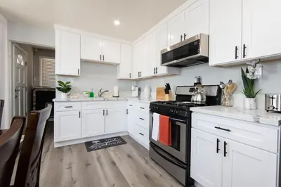 a kitchen with white cabinets and a black stove at Lovely 2bedroom condo with free parking on premise in Los Angeles
