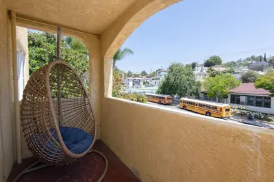 a porch with a swing and a window with school buses at Lovely 2bedroom condo with free parking on premise in Los Angeles