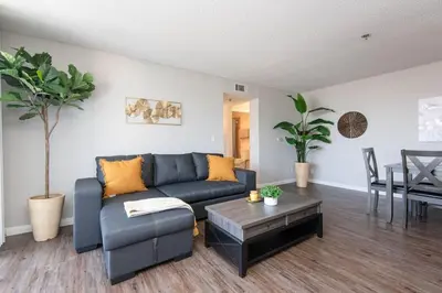 a living room with a blue couch and a table at Hollywood 2Bed Apt w Rooftop pool & Panoramic View in Los Angeles