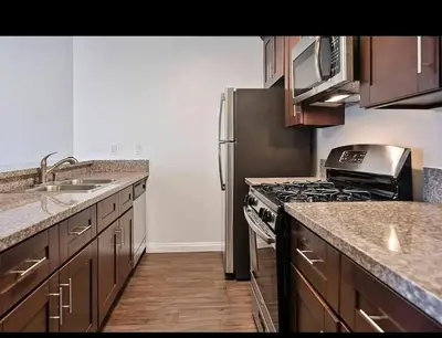 a kitchen with a stove and a refrigerator at Hollywood 2Bed Apt w Rooftop pool & Panoramic View in Los Angeles