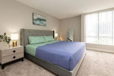 a bedroom with a blue bed and a window at Hollywood 2Bed Apt w Rooftop pool & Panoramic View in Los Angeles