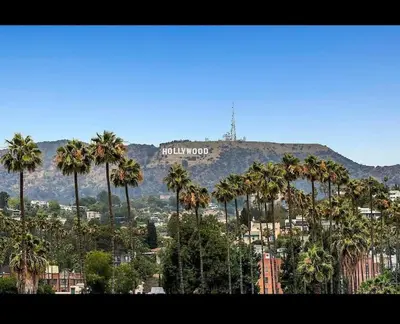 a view of a city with palm trees and a hollywood sign at Hollywood 2Bed Apt w Rooftop pool & Panoramic View in Los Angeles