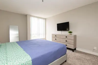 a bedroom with a bed and a dresser with a tv at Hollywood 2Bed Apt w Rooftop pool & Panoramic View in Los Angeles