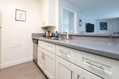 a kitchen with white cabinets and a sink at Hollywood 2Bed Apt w Rooftop pool & Panoramic View in Los Angeles