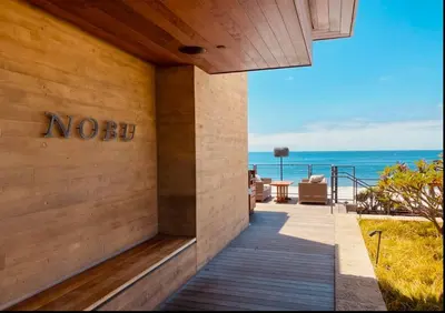 a house on the beach with the ocean in the background at Luxury 1BR Malibu Bungalow on PCH + steps from Beach! in Malibu