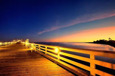 a wooden pier with a fence on the beach at night at Luxury 1BR Malibu Bungalow on PCH + steps from Beach! in Malibu