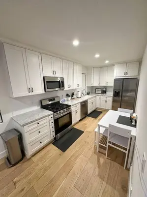a kitchen with white cabinets and a table in it at Luxury 1BR Malibu Bungalow on PCH + steps from Beach! in Malibu