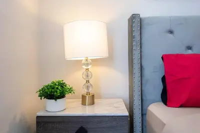 a lamp on a table next to a bed at Hollywood 2Bed Apt w Rooftop pool & Panoramic View in Los Angeles