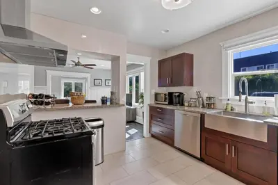 a kitchen with a stove top oven next to a sink at East Village Apartments in Long Beach