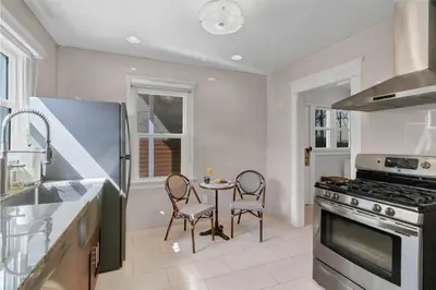 a kitchen with a stove and a table and chairs at East Village Apartments in Long Beach