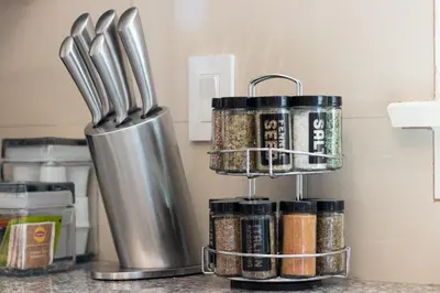 a kitchen counter with a spice rack and cooking utensils at East Village Apartments in Long Beach