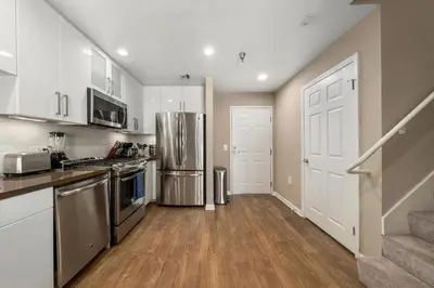 a kitchen with stainless steel appliances and wooden floors at Carnelian Calm-Pool BBQ Rooftop Walk to the Beach in Los Angeles