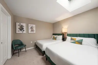 a bedroom with two beds and a chair at Carnelian Calm-Pool BBQ Rooftop Walk to the Beach in Los Angeles