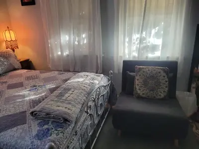 a bedroom with a bed and a chair and a window at Urban Farm House +Hot Tub+Pool in Long Beach