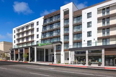 a large white building on a city street at Holiday Inn & Suites Monterey Park – Los Angeles by IHG in Monterey Park