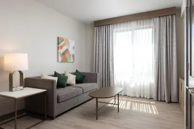 a living room with a couch and a window at Holiday Inn & Suites Monterey Park – Los Angeles by IHG in Monterey Park