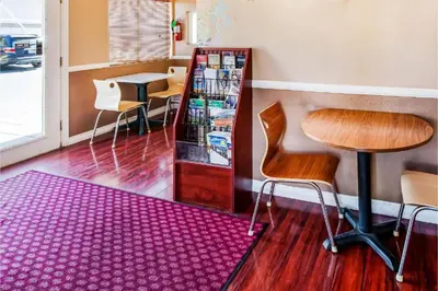a table and chairs in a room with a purple rug at Hotel Europa Ridgecrest in Ridgecrest