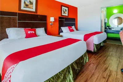 two beds in a hotel room with orange walls at Hotel Europa Ridgecrest in Ridgecrest
