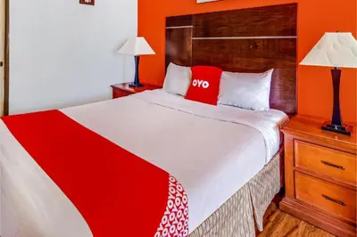 a bedroom with a large bed with an orange wall at Hotel Europa Ridgecrest in Ridgecrest