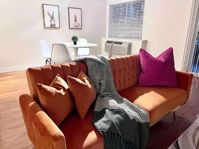 a brown couch with pillows on it in a living room at Ocean 2 min, free pool & parking in Los Angeles