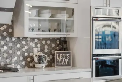 a kitchen with white cabinets and a sign that says lets eat at Voted Airbnb Most Loved Home 2024 Duffy Boat in Huntington Beach