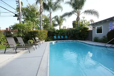 a swimming pool with chairs and palm trees at Destination #06 in Anaheim