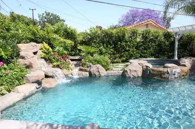 a swimming pool with a waterfall in a yard at Destination #02 in Anaheim