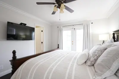 a white bedroom with a bed with a ceiling fan at Destination #02 in Anaheim