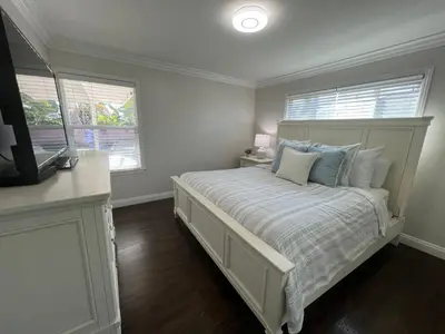 a bedroom with a bed and a tv and two windows at Destination #04 in Anaheim