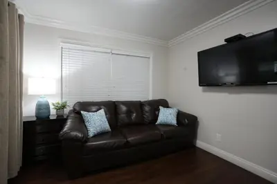 a living room with a brown leather couch and a flat screen tv at Destination #07 in Anaheim
