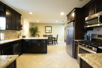 a kitchen with dark wood cabinets and stainless steel appliances at Destination #23 in Anaheim