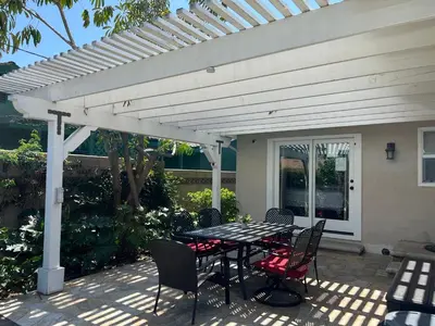 a patio with a table and chairs under a white pergola at Destination #23 in Anaheim