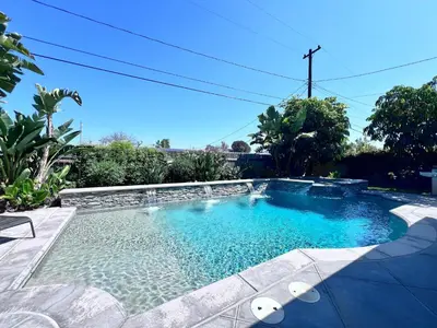a swimming pool with blue water in a yard at Nostalgic PoolJacuzzi Home: GameRm1.8 Mi 2Disney in Anaheim