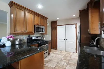 a kitchen with wooden cabinets and a black counter top at Destination #19 in Anaheim