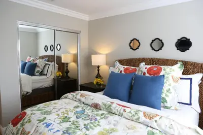 a bedroom with a bed with blue pillows and a mirror at Destination #37 in Fullerton