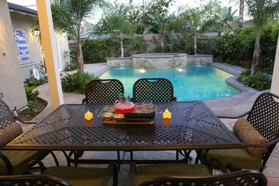 a table with a tray of food and candles on it next to a pool at Destination #05 in Anaheim
