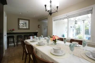 a dining room with a table with plates and flowers on it at Destination #05 in Anaheim