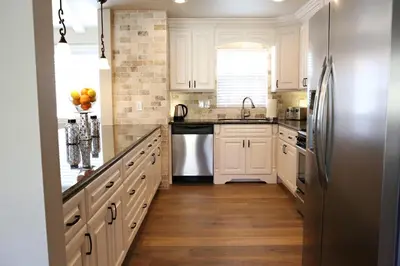 a kitchen with white cabinets and a stainless steel refrigerator at Destination #21 in Anaheim