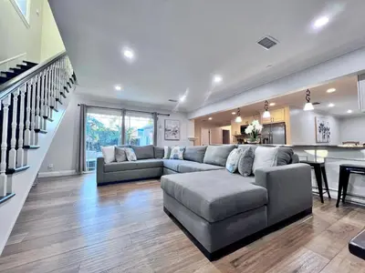 a living room with a large couch and a kitchen at Destination #28 in Anaheim