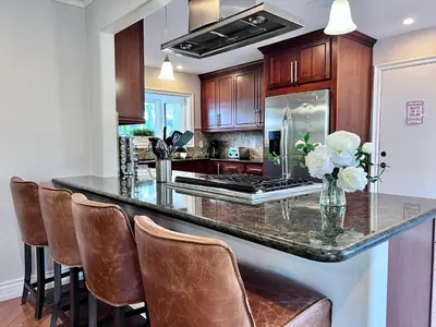 a kitchen with a large island with leather bar stools at Destination #36 in Anaheim