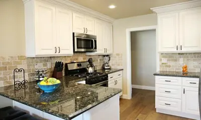 a kitchen with white cabinets and a counter top at Destination #30 in Anaheim